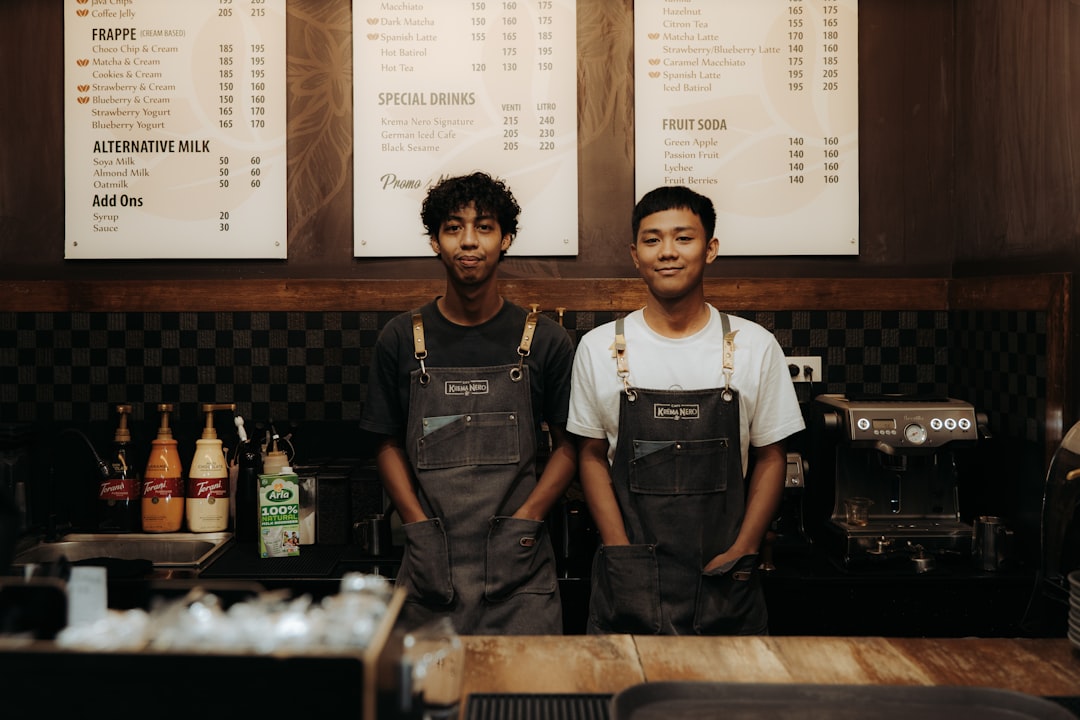 Two baristas smiling behind a counter